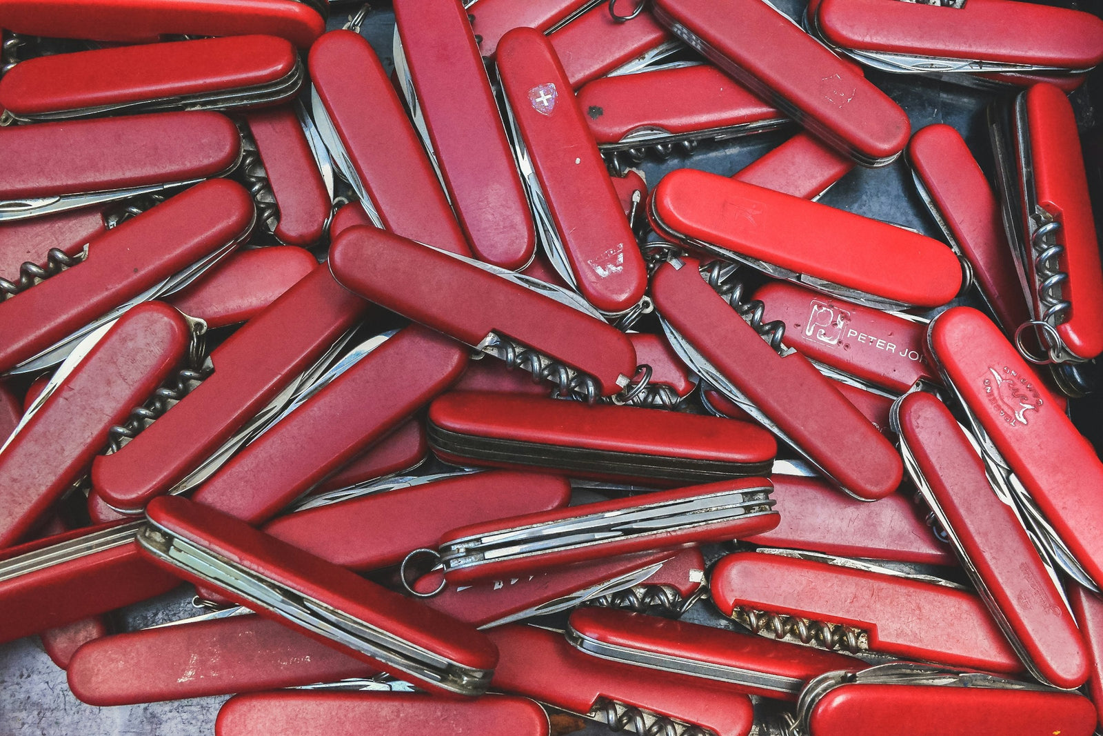 Collection de couteaux suisses aux manches rouges, exemple emblématique de mécanisme slip joint sans verrou