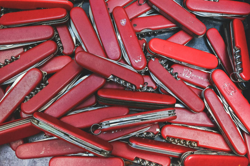 Collection de couteaux suisses aux manches rouges, exemple emblématique de mécanisme slip joint sans verrou